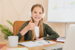 © InsideCreativeHouse - Smiling caucasian student pupil schoolgirl studying online, e-learning on laptop with headphones showing thumb up. Homeschooling concept.