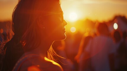 Canvas Print - A woman stands among a group of people watching the sunset, a moment of shared experience and community