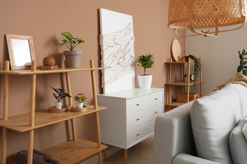Wall Mural - Interior of living room with sofa, pillow, chest of drawers, shelving unit and picture