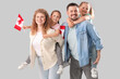 © Pixel-Shot - Happy beautiful family with flags of Canada on grey background