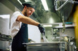© Drazen - Professional cook preparing meal while working in restaurant.