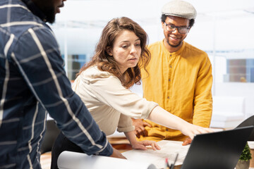 Entrepreneurs collaborating with a real estate agent on office relocation planning, evaluating blueprints of a high class modern space. Discussing investment strategy for a leasing contract.