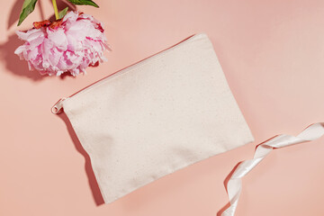 Wall Mural - Canvas cosmetic bag mock-up and pink peony on pastel pink background, top view