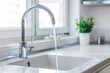 © Anastasiya - Modern white kitchen sink with clean chrome faucet with water flows