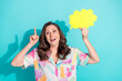 © deagreez - Photo portrait of attractive senior woman eureka hold speech bubble dressed stylish colorful clothes isolated on cyan color background