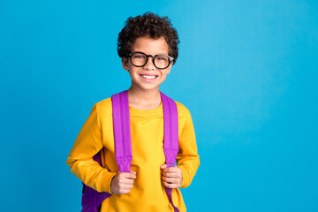 Poster - Photo portrait of cute little boy schoolkid backpack dressed stylish yellow clothes isolated on blue color background