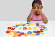 © Arlette - 4 year old Latina brunette girl plays with colored letters and forms the word TDAH which means attention deficit hyperactivity disorder in spanish