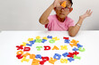 © Arlette - 4 year old Latina brunette girl plays with colored letters and forms the word TDAH which means attention deficit hyperactivity disorder in spanish