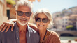 © kora studio - elderly couple on trip in sunny summer italy riviera coast with background of old city architecture town on the coastline.