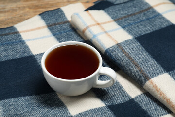 Sticker - Soft checkered scarf and tea on table, closeup