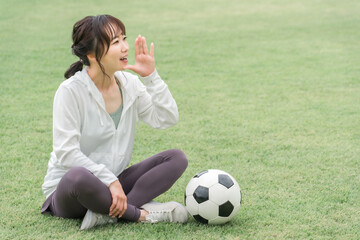 Wall Mural - スポーツウェアでサッカーを応援するアジア人女性
