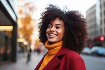 Sticker - Closeup portrait of a beautiful african american woman with afro hairstyle, wearing red coat and scarf, smiling and looking at camera.