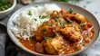 © QAISAR - Recipe for chicken mafe stew with a peanut coconut sauce closeup in a plate on the table