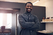 © EmilLL/peopleimages.com - Black man, portrait smile and arms crossed in office for startup, construction business and confidence. African guy, happy architect and entrepreneur with pride, professional and urban planning job