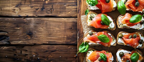 Aufkleber - A wooden table displays tasty sandwiches topped with cream cheese, salmon, capers, and pesto, creating an appetizing copy space image.