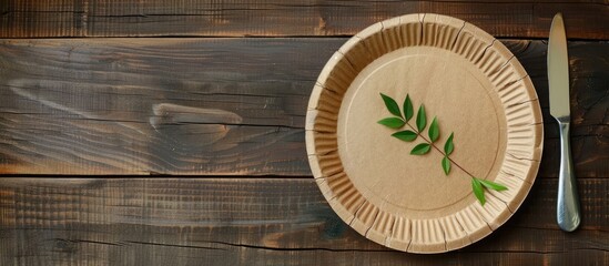 Poster - Empty brown paper plate and fork with knife on a wooden table. View from above. Eco-friendly disposable tableware. copyspace. Copy space image. Place for adding text or design