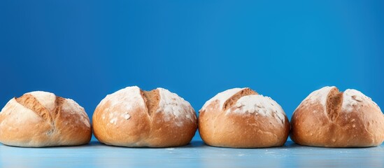 Poster - Three freshly baked loaves of bread are arranged in the corner against a blue backdrop, leaving space for your text. with copy space image. Place for adding text or design