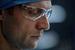 © Seventyfour - Extreme closeup portrait of focused surgeon wearing protective glasses looking down in operating room copy space