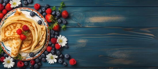 Leinwandbilder - Top view copy space image of European holiday Maslenitsa with traditional thin crepes adorned with berries, jam, and honey on a blue wooden table.
