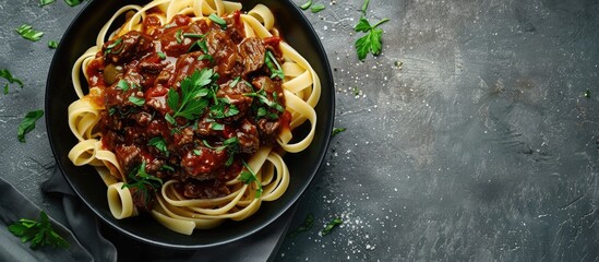 Poster - Top view of a black bowl filled with fettuccine pasta and beef ragout sauce on a grey backdrop, ideal for adding text or images (copy space image).