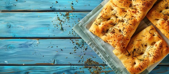 Poster - Top view arrangement of focaccia bread on a blue wooden surface with room for text in the image. with copy space image. Place for adding text or design