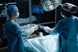 © Seventyfour - Side view portrait of medical assistant handing tools to surgeon performing surgery in operating room