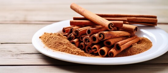 Leinwandbilder - Cinnamon sticks and ground spice beautifully arranged on a white plate against a light wooden backdrop, perfect for a copy space image.