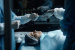 © Seventyfour - Close up of two surgeons performing surgery with focus on female patient lying on operating table