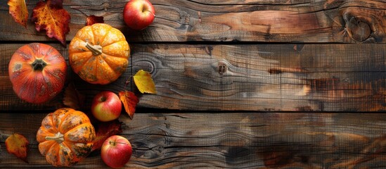 Poster - Wooden background with a pumpkin and red and yellow apples setup for a perfect autumn copy space image.