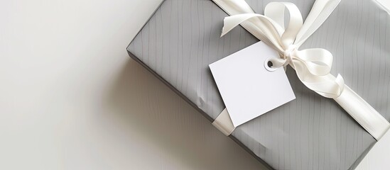 Canvas Print - Top view of gray gift box with a white bow and tag, set against a white background, ideal for copy space image.
