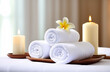 © VVstudio - Fresh white towels with candles and frangipani on blurred background of spa room