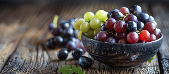 Wall Mural - Selective focus on a variety of red, white, and black grapes in a bowl on a dark wooden table with a copy space image.