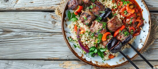 A rustic plate with a delectable Grilled Aubergine lamb shish kebab (patlican kebabi), adorned with spicy tomato sauce, herbs, onion, bulgur, and a grilled hot green pepper, set on a wooden backdrop