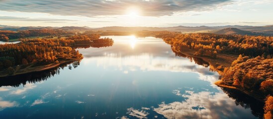 Wall Mural - A serene aerial photograph capturing the autumn sun reflecting on a vast lake with ample space for text or graphics - a scenic copy space image.