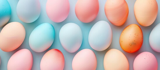 A variety of colorful eggs including pink, golden, orange, and blue arranged in a top view flat layout with space for text or designs, known as a copy space image.