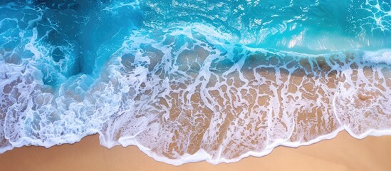 Canvas Print - Turquoise ocean waves gently caressing a sandy beach, captured in a high-angle copy space image.