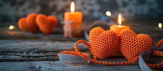 Aufkleber - Valentine's Day-themed orange crocheted hearts with ribbon and a candle arranged on a wooden table, with copy space image available.
