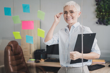 Sticker - Photo of attractive good mood age lady recruiter dressed formal shirt holding documents indoors workplace workstation