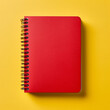 © Nasreen - A red notebook placed in the top right corner of a solid yellow background, ready for taking notes.