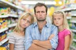 © volga - Frustrated father shopping with bored daughters in grocery store