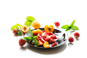 Wall Mural - fresh fruit salad of ripe strawberries and apricots, isolated on a white background