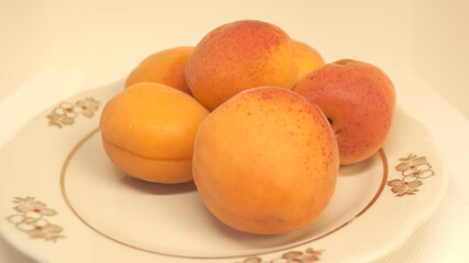 ripe apricots on a white plate	
