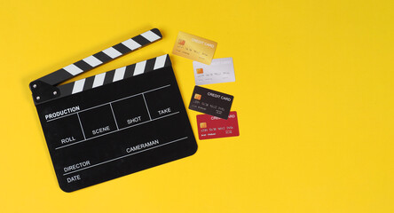 Wall Mural - Clapper board with creit cards on yellow background.