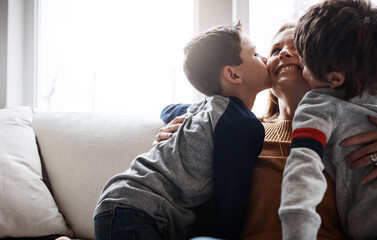 Wall Mural - Love, kiss and children with mom on a sofa for happy mothers day, gratitude and bonding in their home together. Family, hug and kid siblings with woman in a living room for support, trust or safety