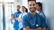 © Irina Ukrainets - Smiling medical professionals in blue scrubs standing in a hospital corridor. Group of happy diverse doctors ready to assist. Healthcare teamwork and medical staff portrait concept. AI