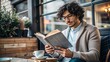 © nadunprabodana - young man reading in cafe