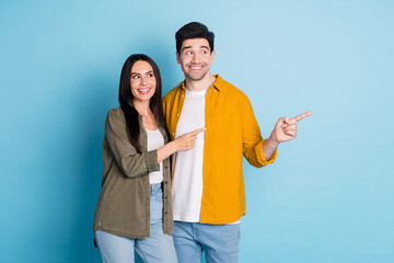 Wall Mural - Photo of two nice young partners look direct fingers empty space wear shirt isolated on blue color background