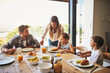 © Stratford/peopleimages.com - Family, breakfast and morning in house with cereal, juice and fruit for health or nutrition by table. Woman, dad and kids together in home with food for wellness, brunch and bonding with mom help