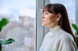 © Valerii Honcharuk - Serious thoughtful middle aged female looking out the window at home