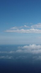 Wall Mural - aerial view. blue sky sun and fog over calm sea. the drone flies over foggy and fluffy clouds. abstr